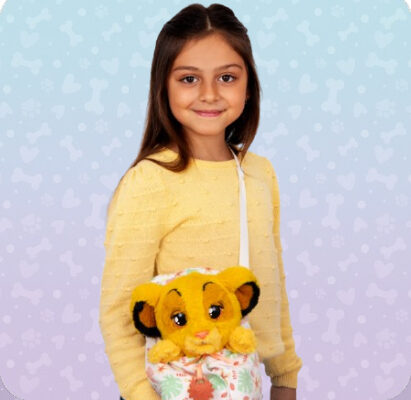 Dziewczynka z żółtym Psytulaskiem od Epee w nosidełku – uroczy, interaktywny piesek gotowy na wspólne spacery, zabawę i przytulanie w każdej chwili.