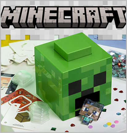Zielone pudełko w kształcie głowy Creepera z zestawu Naklejkomat 3D Minecraft, otoczone kolorowymi naklejkami i elementami dekoracyjnymi inspirowanymi światem gry Minecraft.