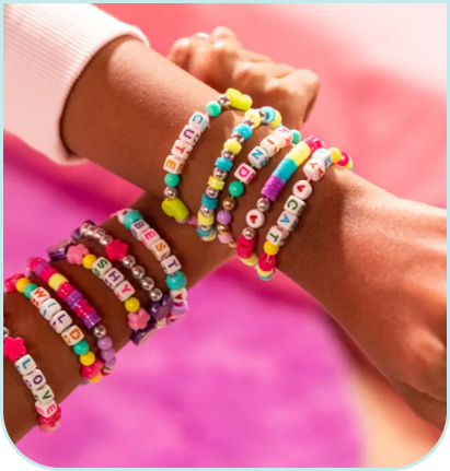 Kolorowe bransoletki z koralików i literek wykonane zestawem Style 4 Ever Projekt Glam – Zakręcony Kreator Bransoletek, prezentowane na nadgarstkach.